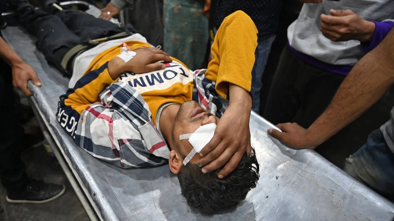 Kashmiri volunteers and medical workers carry an injured youth wounded by pellet fire during clashes in south Kashmir's Kulgam district, at a hospital in Srinagar, 29 May 2019 (Tauseef Mustafa/AFP)