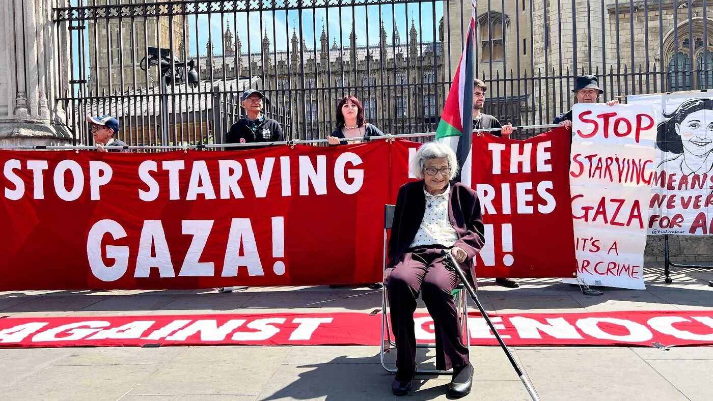 Laila Soueif sits in front of a protest against Israel's war on Gaza outside the Houses of Parliament, London on 20 May 2025 (MEE/Hossam Sarhan)