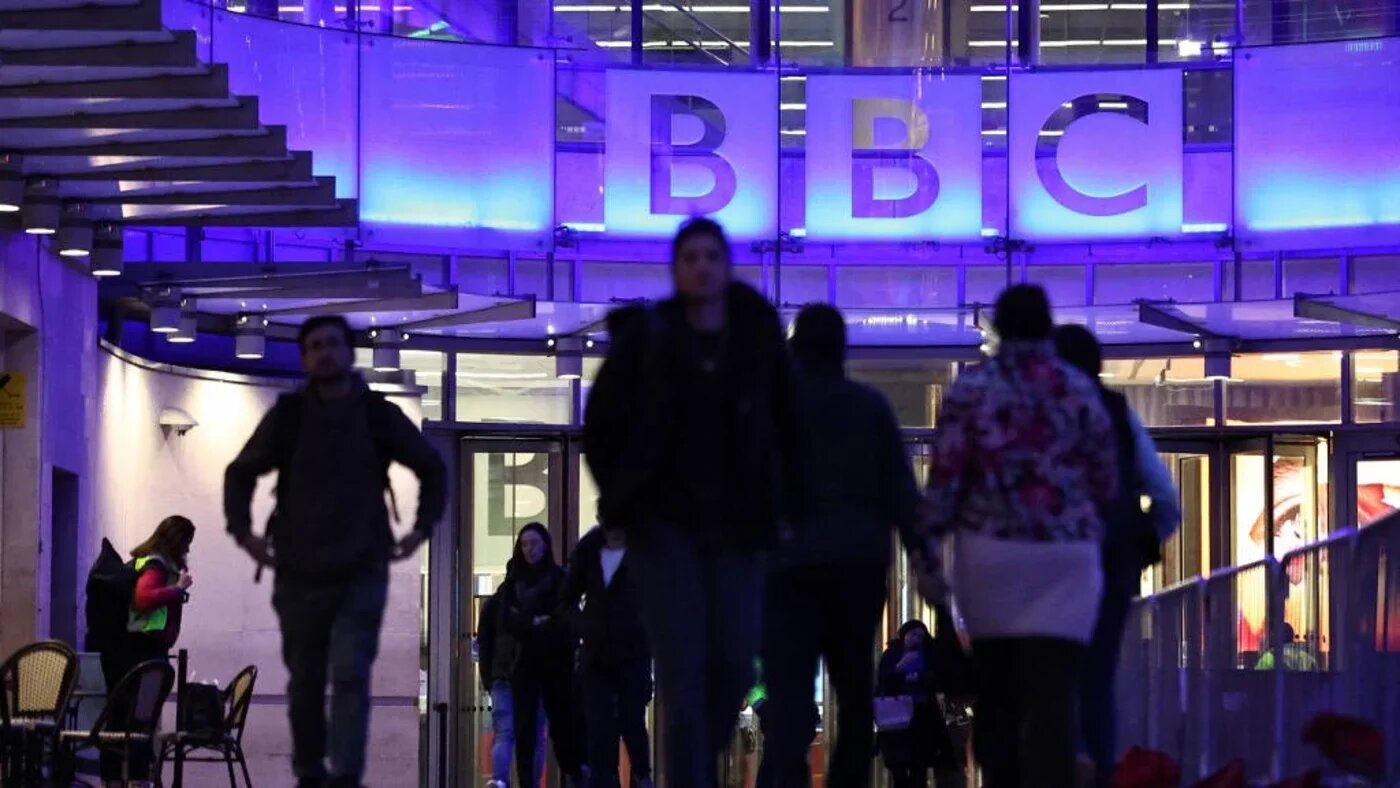 People use the entrance to the offices of British broadcaster BBC in London on 11 November 2025 (AFP)