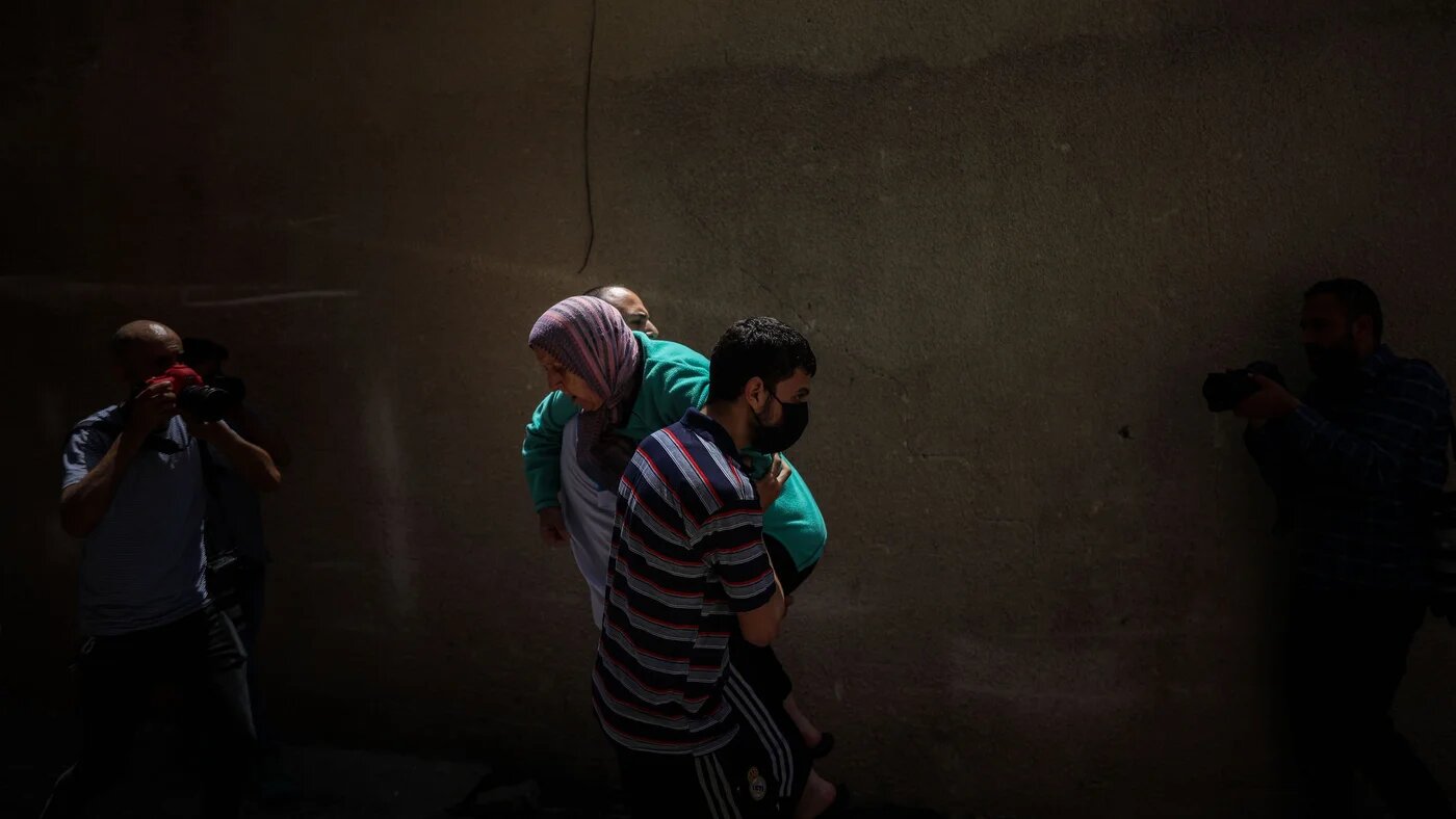 Man carries injured woman in Gaza
