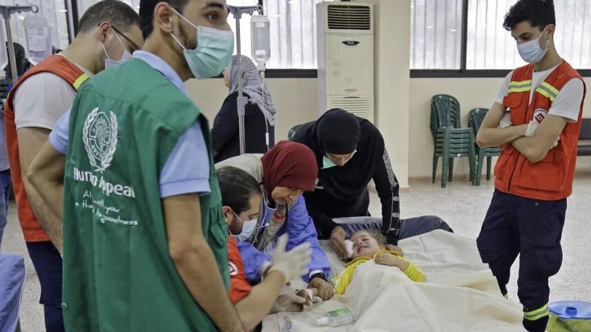 Medical staff treat a child with cholera at a ward in a mosque converted into a hospital in Bebnine, northern Lebanon, 26 October 2022 (AFP)