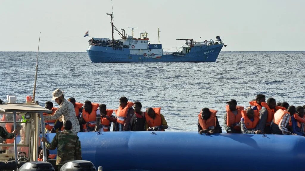 Migrants on a rubber boat are helped by a Libyan coast guard patrol during a rescue operation with a ship run by a German NGO, in November 2016 (Andreas Solaro/AFP)