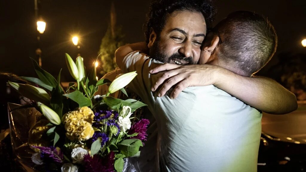 Moroccan journalist Omar Radi (left) hugs his friend after leaving prison in Rabat on 29 July (Fadel Senna/AFP)