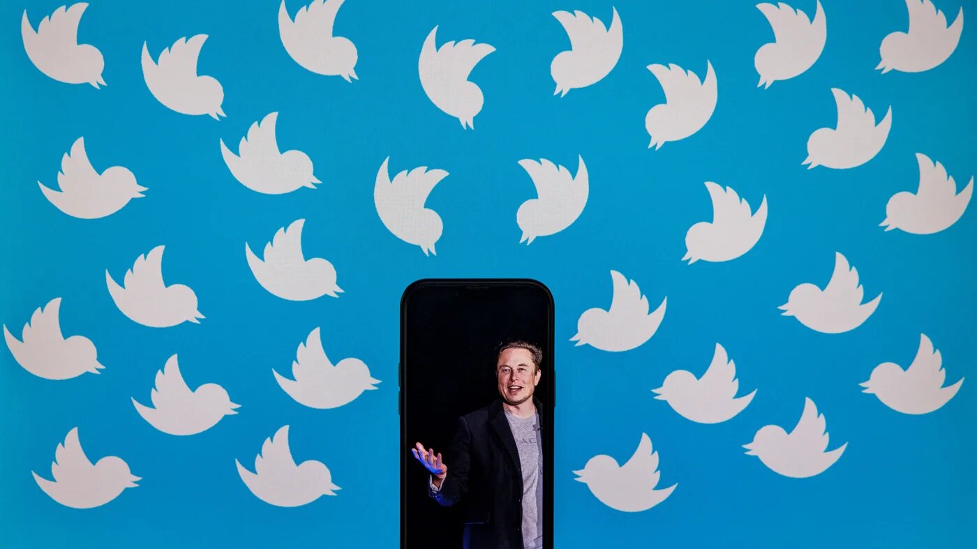 In this file photo illustration taken on August 05, 2022, shows a cellphone displaying a photo of Elon Musk placed on a computer monitor filled with Twitter logos in Washington, DC.