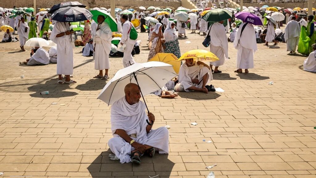 Muslim pilgrims use umbrellas to shade themselves from the sun as they arrive at the base of Mount Arafat during the annual Hajj pilgrimage on 15 June 2024 (Fadel Senna/AFP)