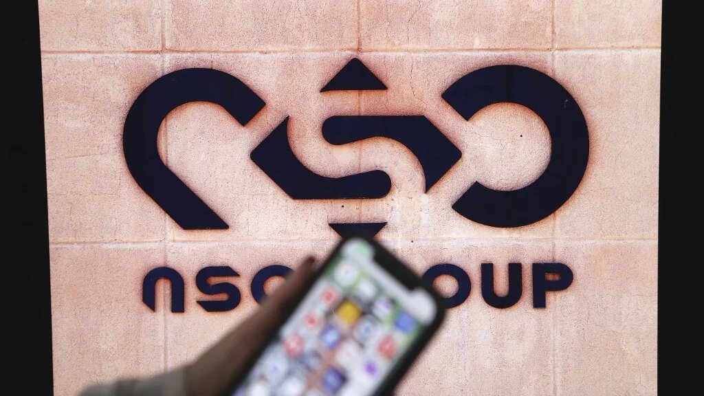 A photographic illustration shows a mobile phone near the NSO Group company logo in February 2022 in the Israeli city of Netanya (AFP)