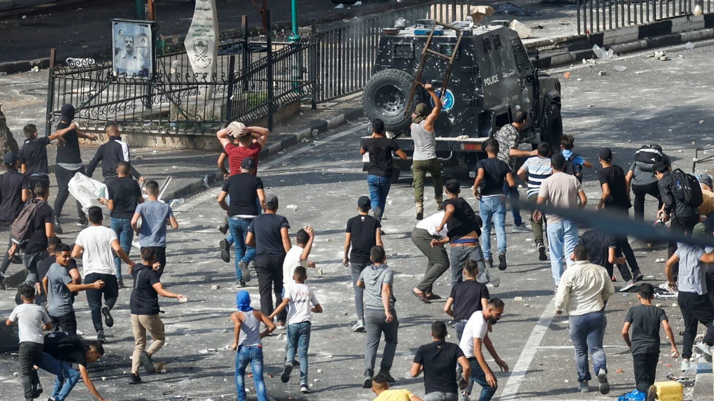Palestinian demonstrators protesting the arrest of two Palestinian fighters clash with Palestinian security forces, in Nablus in the occupied West Bank, 20 September 2022 (Reuters)