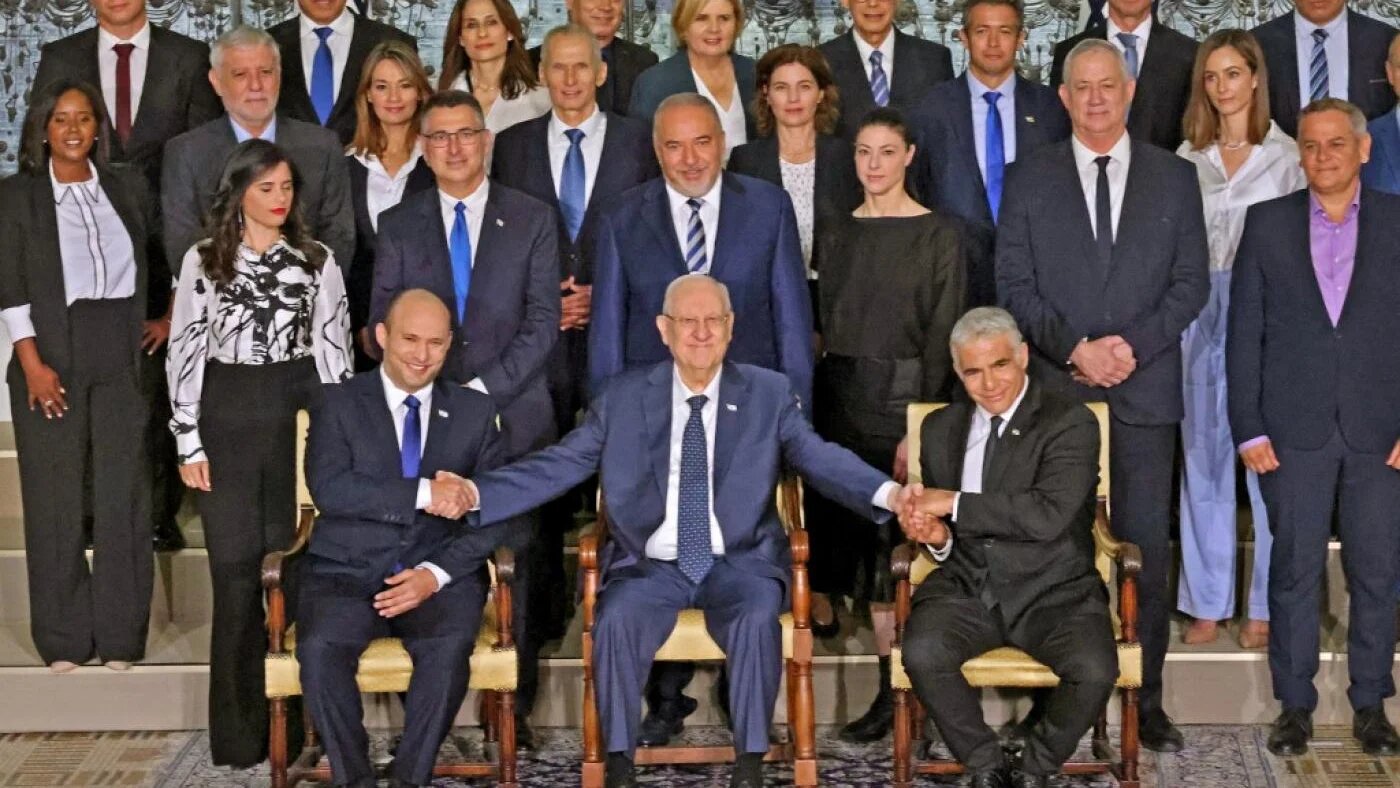 Le président sortant Reuven Rivlin entouré de Naftali Bennett (à gauche) et Yaïr Lapid (à droite) dans la résidence du président à Jérusalem, le 14 juin 2021 (AFP)