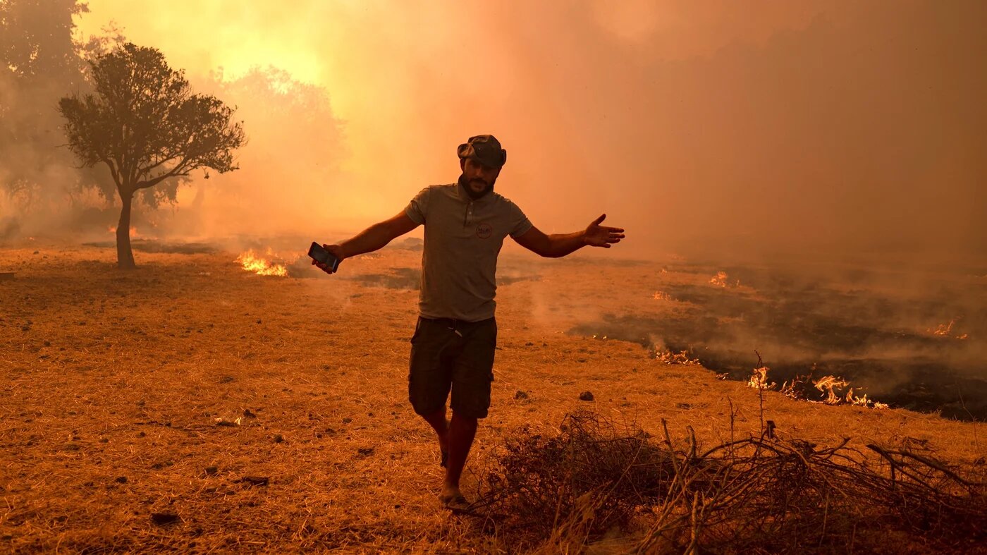 Un homme fuit devant le feu qui avance, dans la région de Marmaris, le 2 août 2021 (AFP/Yasin Akgül)