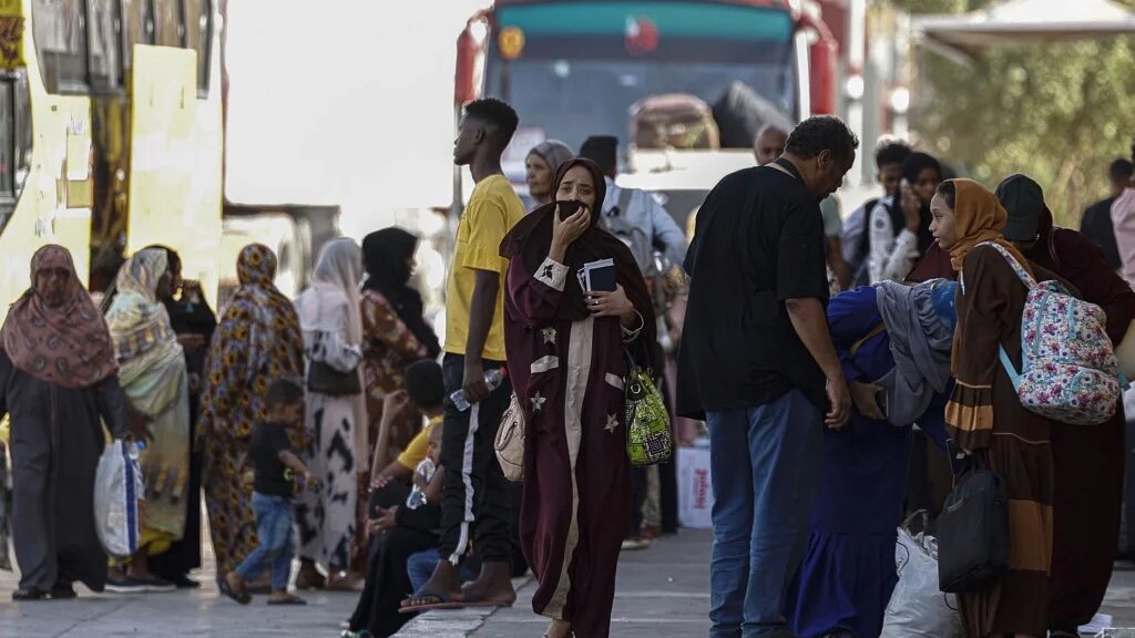 Passengers fleeing war-torn Sudan arrive at the Qastal land crossing between Egypt and Sudan on 13 May 2023 (AFP)