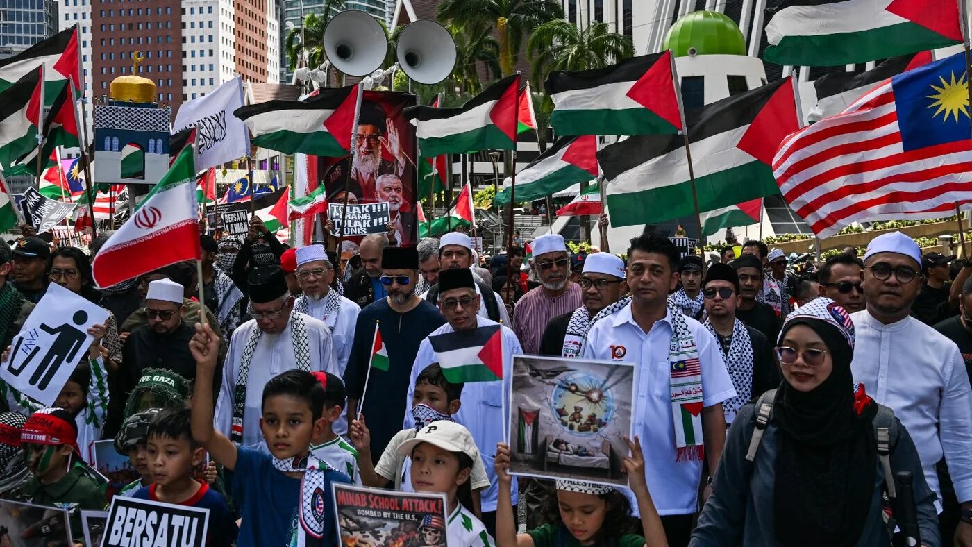 People hold placards and Palestinian flags during a demonstration marking Al-Quds (Jerusalem) Day after Friday prayers in Kuala Lumpur, 13 March 2026 (Mohd Rasfan/AFP)