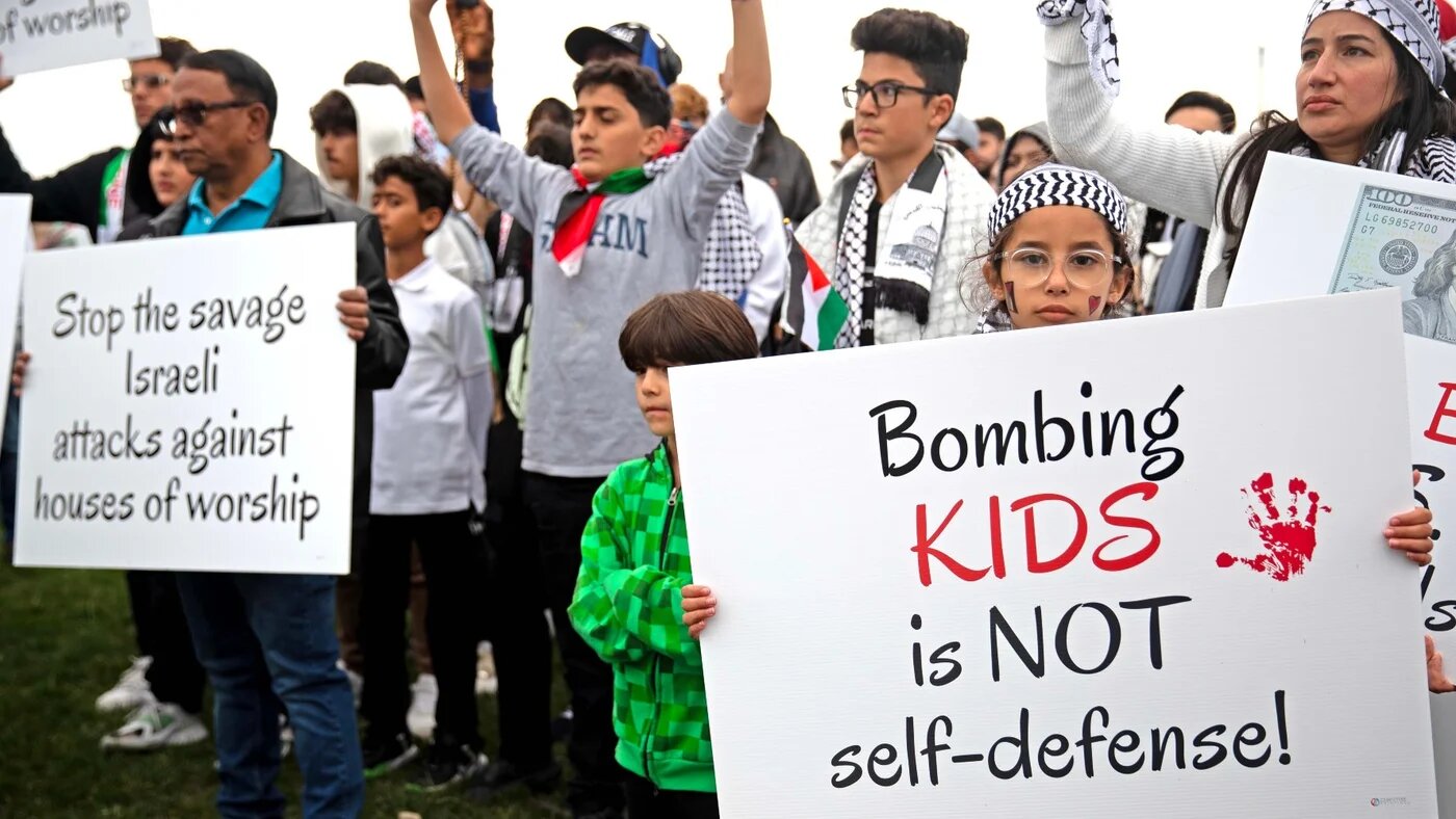 People hold up signs and flags to show their support for Palestinians at the Islamic Society of Milwaukee on 10 October, 2023 (Reuters)