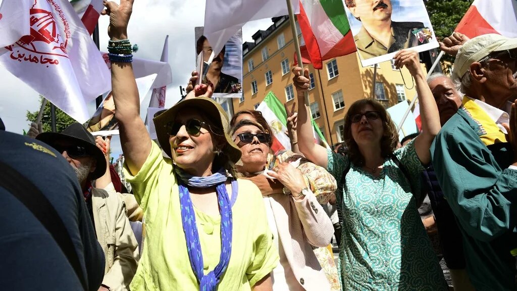 People react outside Stockholm District Court in Stockholm, Sweden, on 14 July 2022, after the life sentence in the war crime trial against Hamid Noury was announced (AFP)