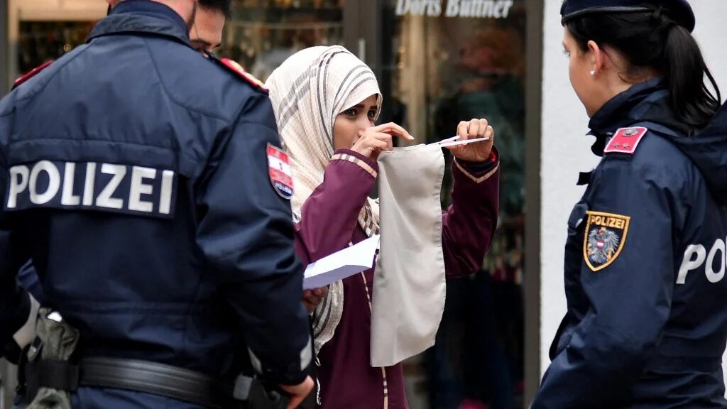 Police officers ask a woman to unveil her face in Zell am See, Austria, on 1 October 2017, following the country's ban on full-face Islamic veils coming into force (AFP)