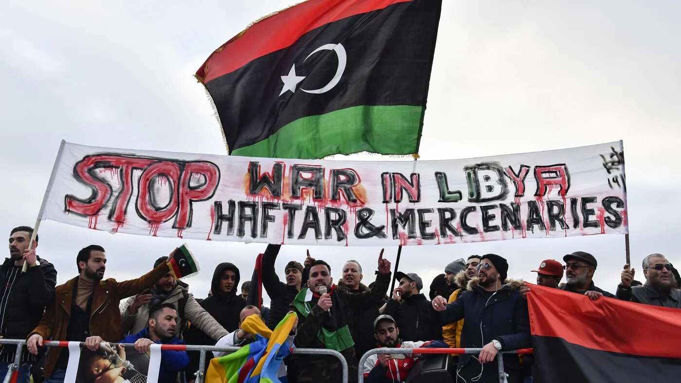 Protesters hold a banner reading 'Stop war in Libya, Haftar and mercenaries' during a protest near the chancellery during the Peace summit on Libya at the Chancellery in Berlin on 19 January, 2020.