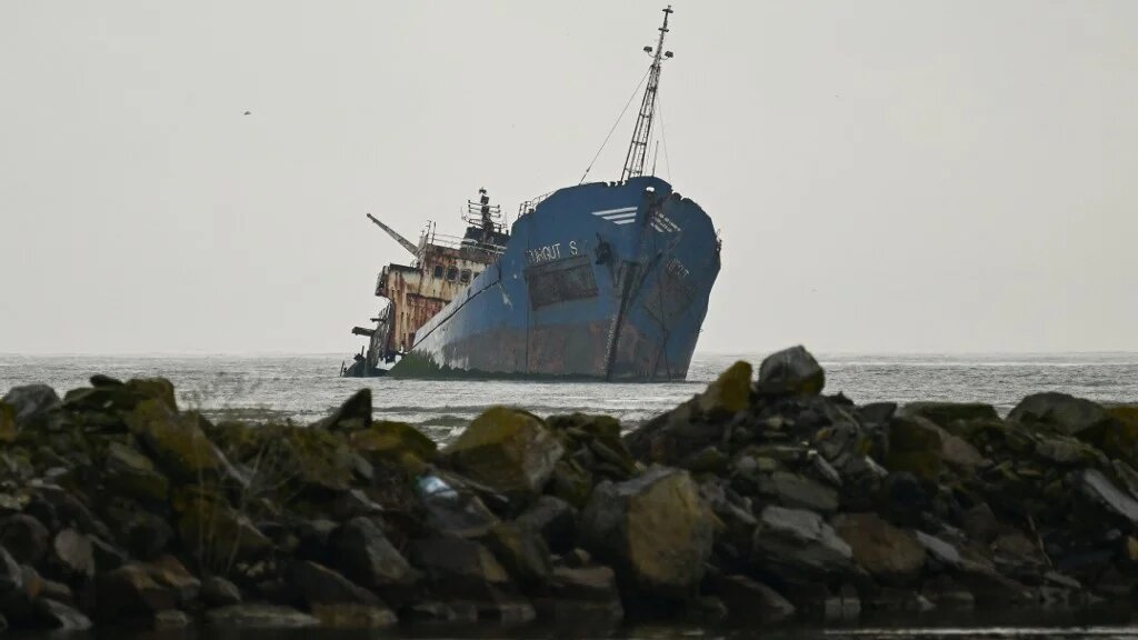 The rusting hull of the cargo ship Turgut S (also known as Turgut Usta) lies partially submerged in the shallow waters of Musura Bay, near the Black Sea port of Sulina, eastern Romania, on May 10, 2026. (Daniel MIHAILESCU / AFP)