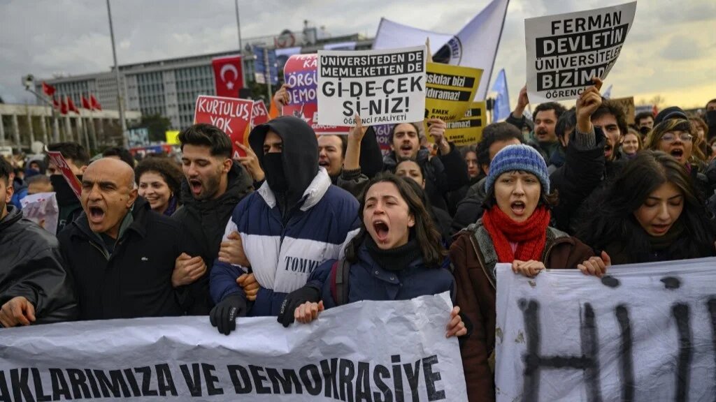 Students hold signs and banners as they march in protest towards the Istanbul Municipality in Istanbul, on 20 March (Yasin Akgul/AFP)