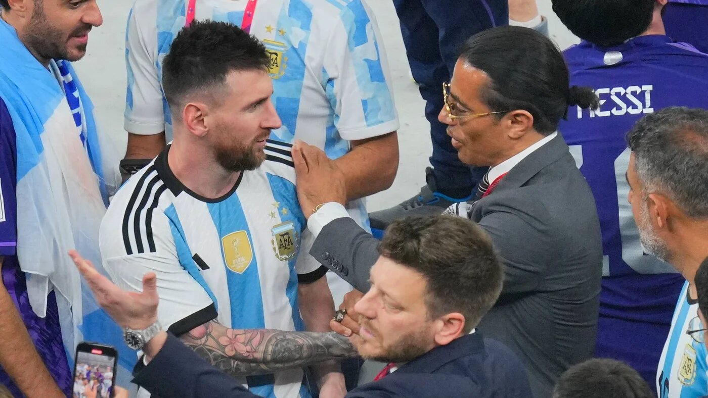 Salt Bae puts his hand on the shoulder of Argentina's Lionel Messi end of the Qatar World Cup final match at the Lusail Stadium, 18 December 2022 (AP)