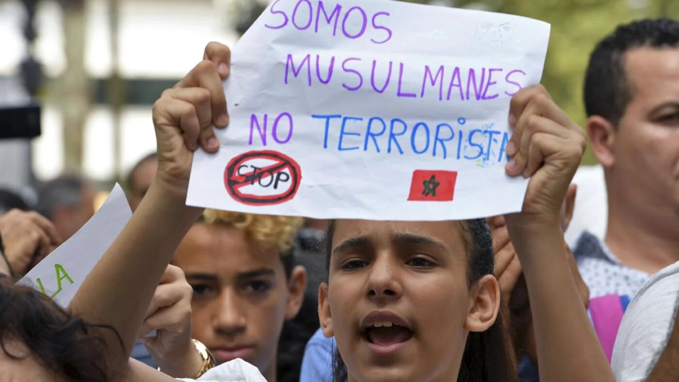 Une jeune fille brandit un message où on peut lire « Nous sommes musulmans, pas terroristes » pendant une manifestation des résidents musulmans de Barcelone contre le terrorisme et en hommage aux victimes de l’attentat de Barcelone, le 19 août 2017 (AFP)