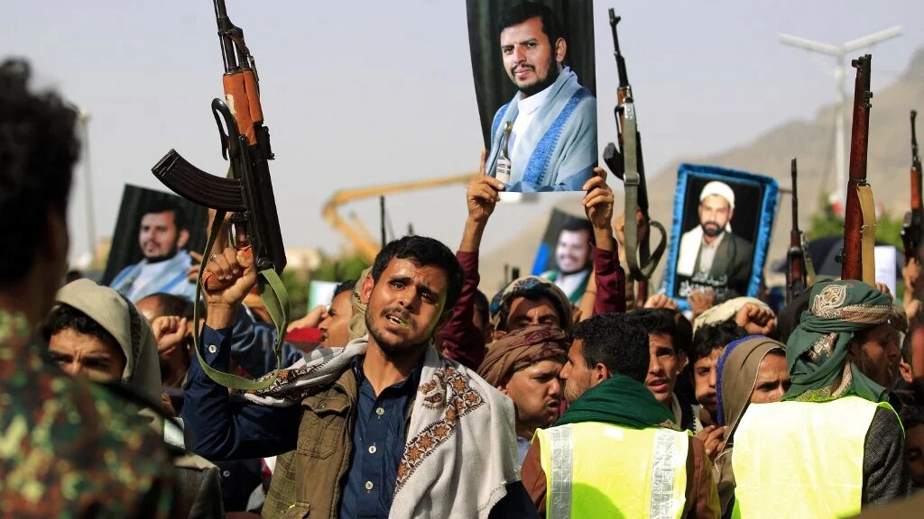 Supporters of Yemen's Houthi rebels raise portraits of their leader Abdul Malik al-Houthi during a rally in the capital Sanaa on 3 June 2022 (AFP)