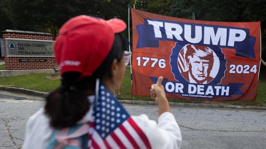 A supporter of former President Donald Trump outside the Fulton County Jail, Atlanta, Georgia, ahead of his expected arrival for indictment on 24 August 2023 (AFP)