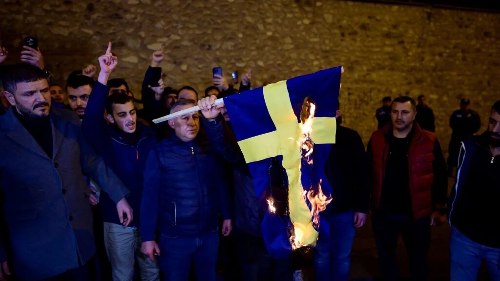 Protesters burn the national flag of Sweden as they demonstrate in front of the Consulate General of Sweden after Rasmus Paludan, leader of Danish far-right political party Hard Line and who also has Swedish citizenship burned a copy of the Koran near the Turkish Embassy in Stockholm, in Istanbul, on January 21, 2023. (AFP)