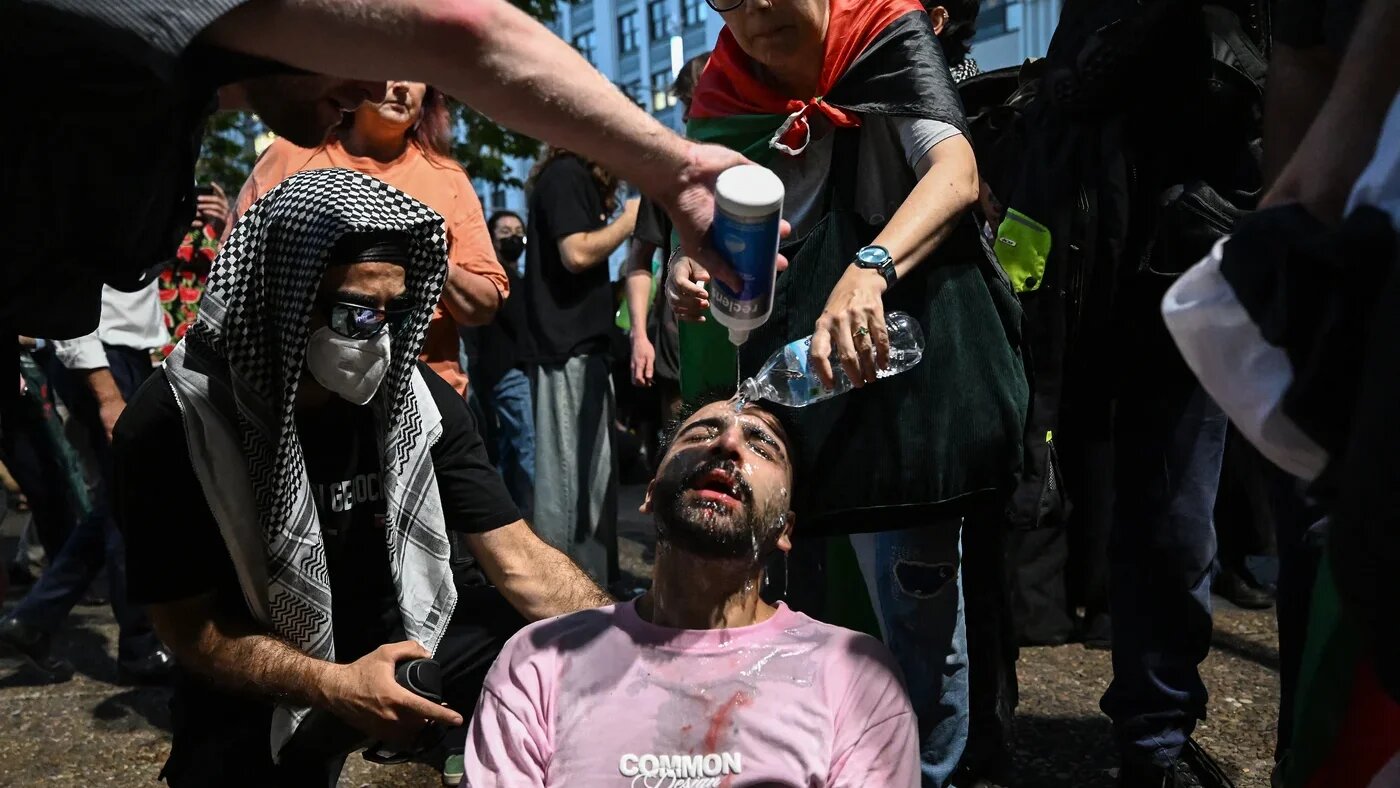 A protester is helped after police deployed pepper spray at a pro-Palestinian rally in Sydney, Australia on 9 February 2026 (Saeed Khan/AFP)