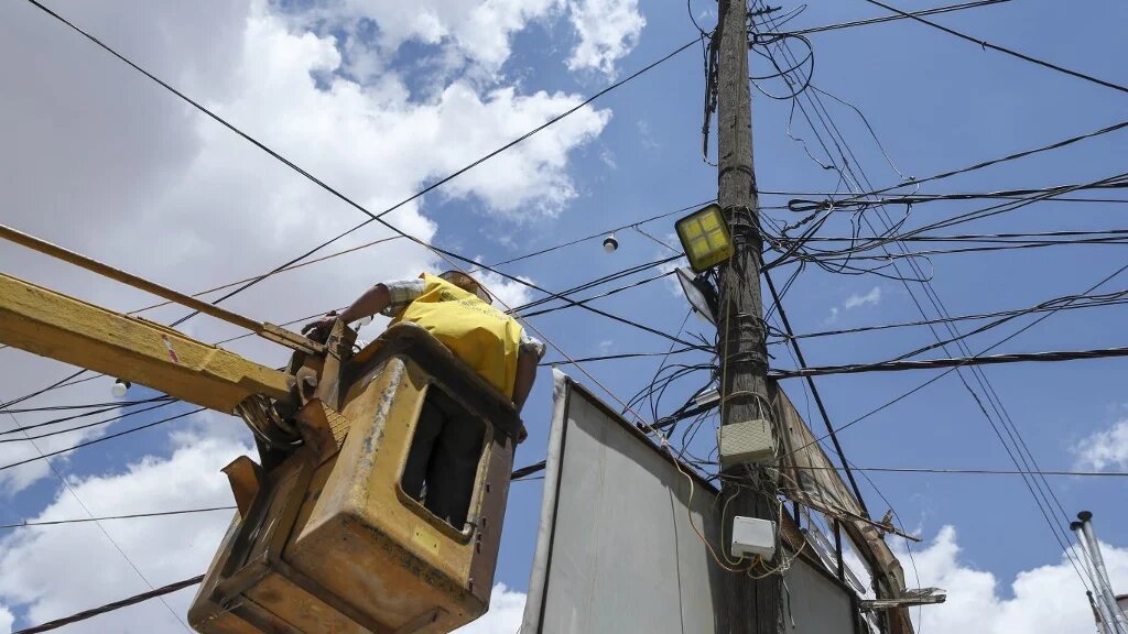 A Syrian electricity company worker carries out maintenance work on power lines in the rebel-held northwestern city of Idlib on June 6, 2021. (Omar Haj Kadour / AFP)