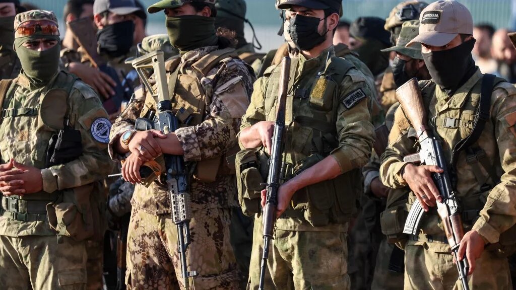 Military fighters affiliated  Hayat Tahrir al-Sham (HTS), attend prayers at an open air stadium on the first day of the Muslim Eid al-Adha holiday marking the end of the hajj pilgrimage to Mecca, in Idlib on June 16, 2024. (Omar Haj Kadour / AFP)