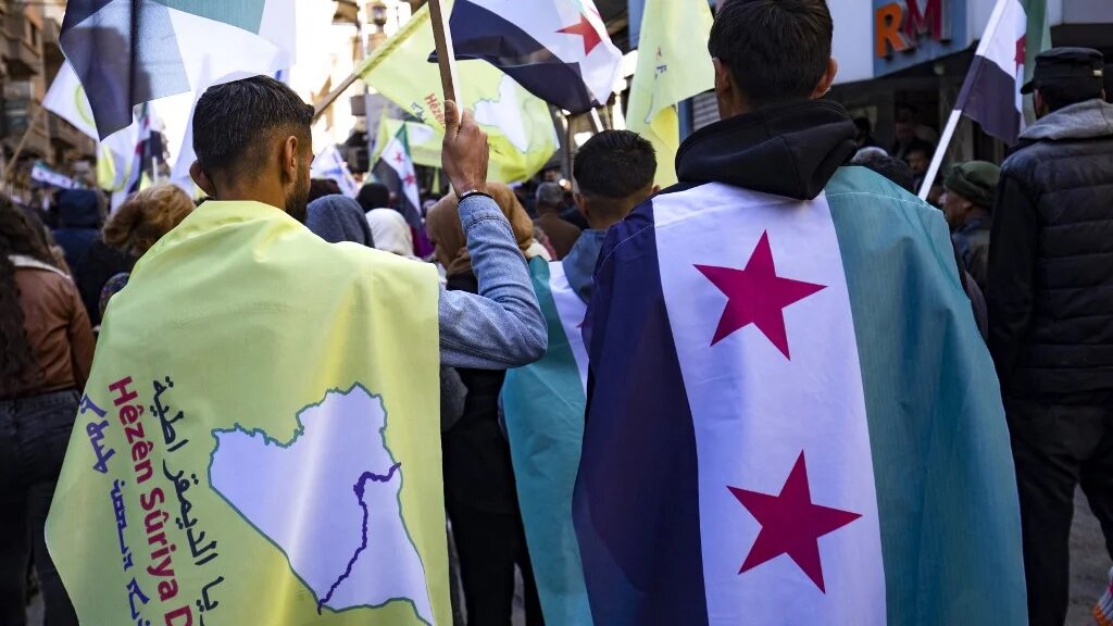 Syrian Kurds wave independence-era flags at a demonstration in support of the US-backed, Kurdish-led Syrian Democratic Forces in Qamishli on December 19 2024.  (Delil Souleiman / AFP)