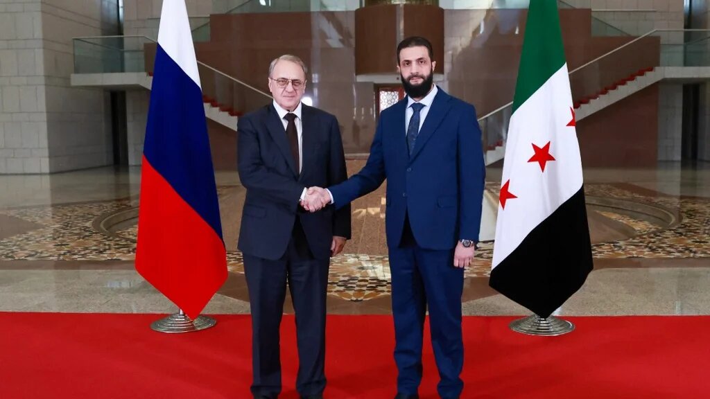 Syria's new leader, Ahmed al-Sharaa (R), and Russian Deputy Foreign Minister Mikhail Bogdanov (L) pose for a photo during their meeting in Damascus in a handout image released on 29 January 2025 (AFP Photo/Syria Transitional Government)