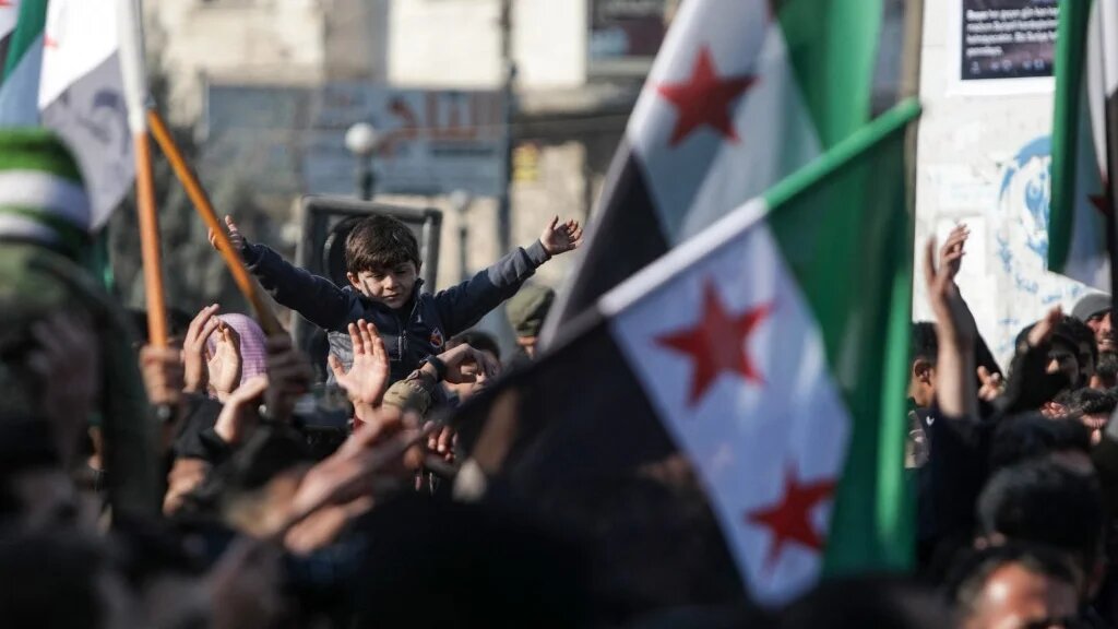 Demonstrators raise Syrian opposition flags and placards as they rally against a potential rapprochement between Ankara and the Syrian regime, on December 30, 2022, in the opposition-held city of al-Bab, on the border with Turkey (AFP)