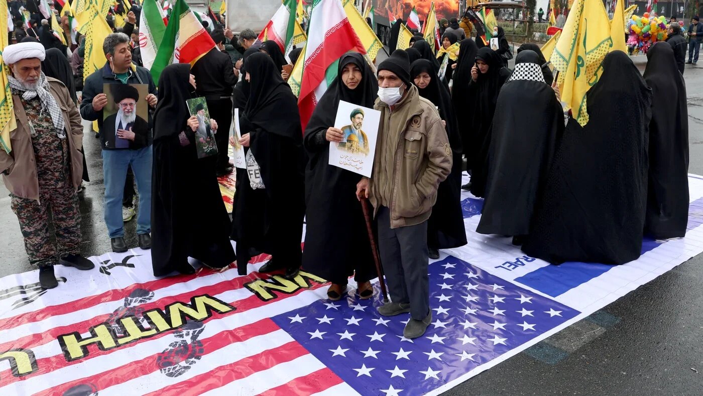 Iranians stand on a large US flag during an al-Quds Day, an annual event in support of Palestinians, weeks after Israel and the US launched strikes on Iran that triggered a regional war, in Tehran on 13 March 2026 (AFP)