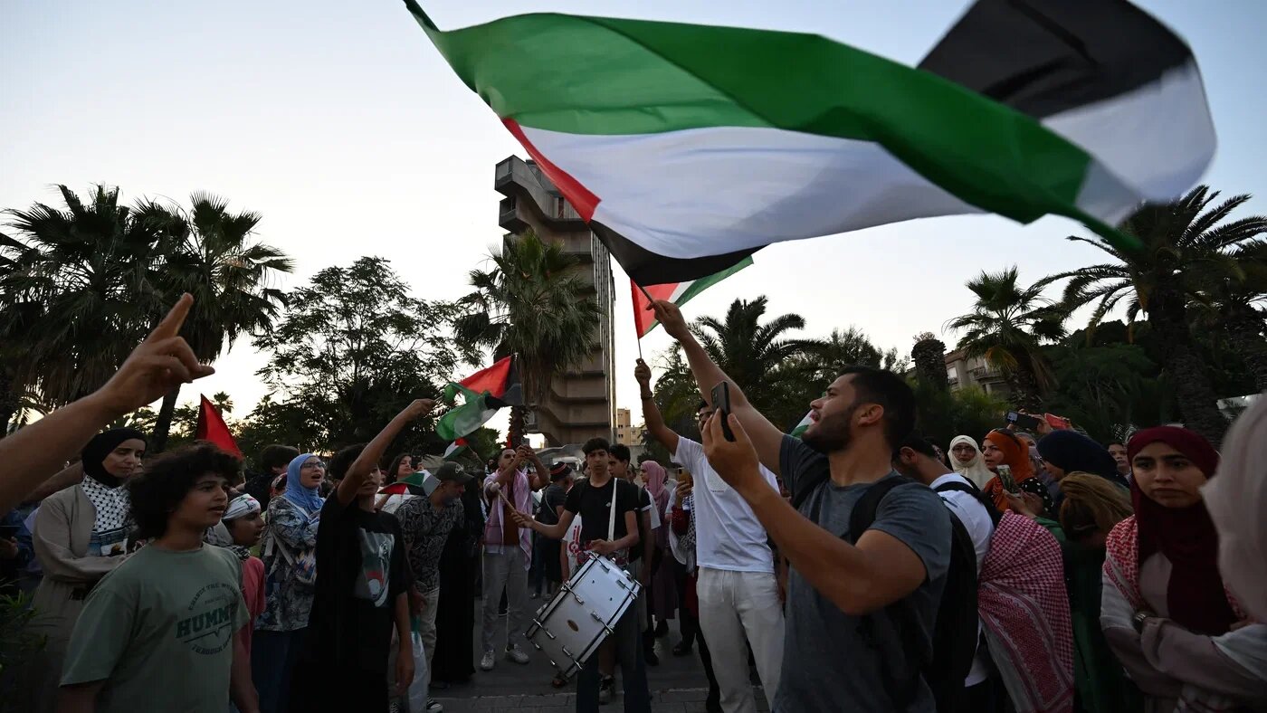 Tunisians wave the Palestinian flag as they gather in Tunis on 9 June 2025, ahead of the departure of a land convoy named Sumud, meaning steadfastness, to break the siege on Gaza (Fethi Belaid/AFP)