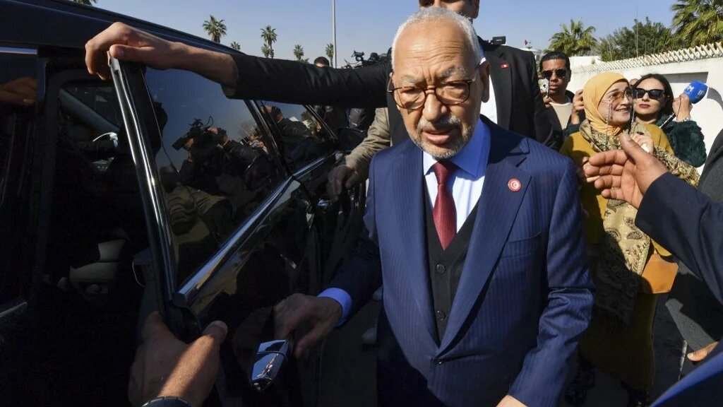 The head of Tunisia's opposition party Ennahda Rached Ghannouchi greets supporters upon arrival to a police station in Tunis, on 21 February 2023 (Fethi Belaid/AFP)