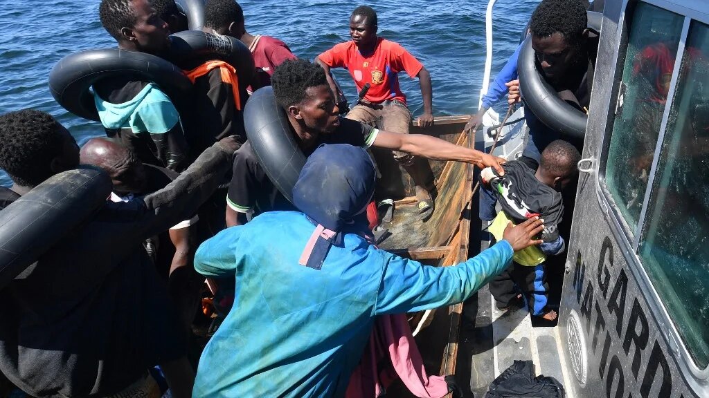 People trying to flee to Europe are transferred from their small boat onto a vessel belonging to the Tunisian National Guard, at sea between Tunisia and Italy, on 10 August 2023 (Fethi Balaid/AFP)