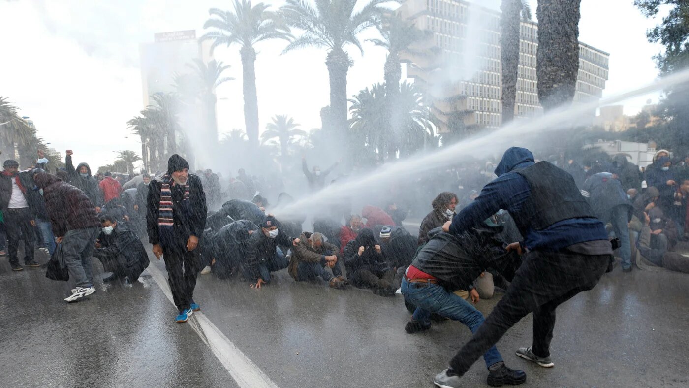 Dans des scènes d’une violence qui n’avait plus été vue dans la capitale depuis dix ans, les policiers ont chargé les manifestants à grand renfort de canons à eau, gaz lacrymogènes et ont procédé à des dizaines d’arrestations musclées, le 14 janvier à Tunis (AFP/Fethi Belaïd)