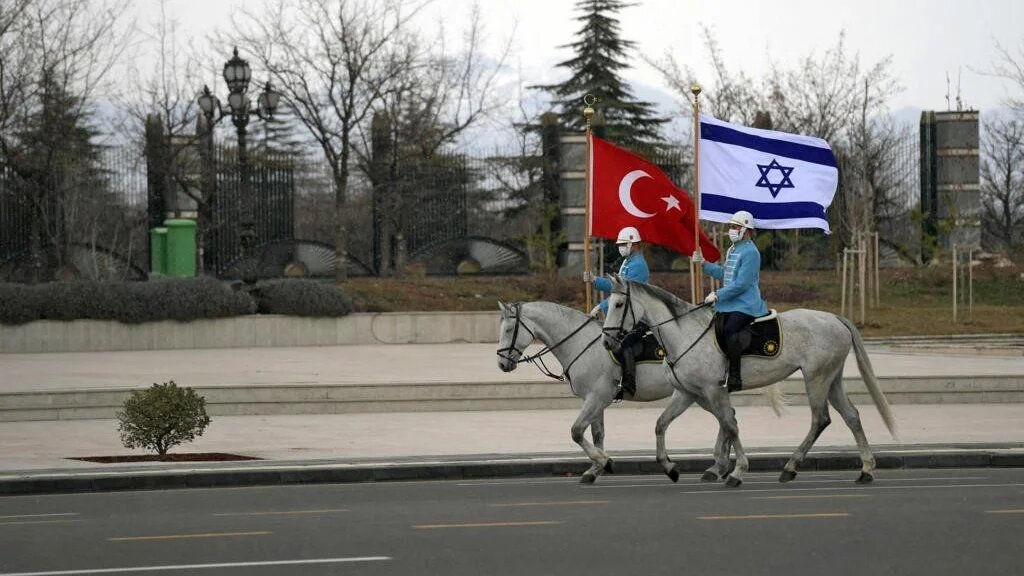 A handout picture obtained from the Israeli Government Press Office (GPO) on March 9, 2022, shows Turkish cavalry guards waving the Israeli (R) and Turkish flags, to welcome the Israeli president in the capital Ankara. (AFP)