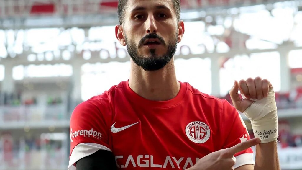 This handout photograph taken and released by Turkish news agency DHA (Demiroren News Agency) shows Antalyaspor's Israeli forward Sagiv Jehezkel displaying a bandage on his wrist reading "100 days. 07/10" after scoring a goal during Turkish Super league match between Antalyaspor and Trabzonspor at Corendon Airlines Park Antalya Stadium, in Antalya on January 14, 2024. (AFP)