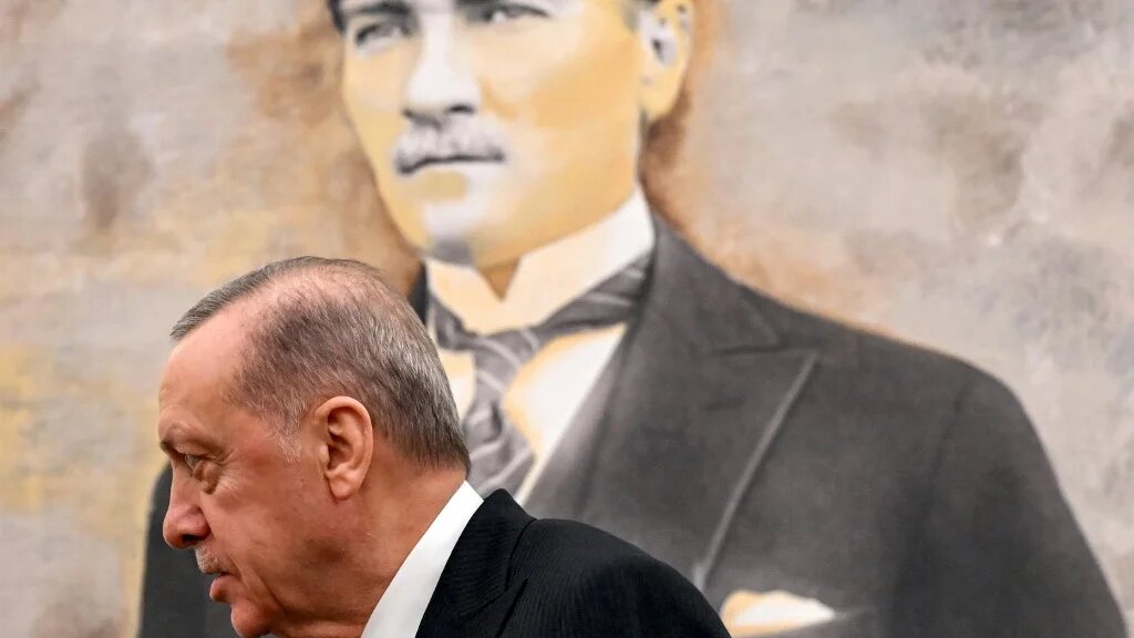 urkey's President Recep Tayyip Erdogan stands before a picture of the founder and first president of the Turkish Republic Mustafa Kemal Ataturk  at Ankara Esenboga Airport on December 12, 2024. (ANDREW CABALLERO-REYNOLDS / POOL / AFP)