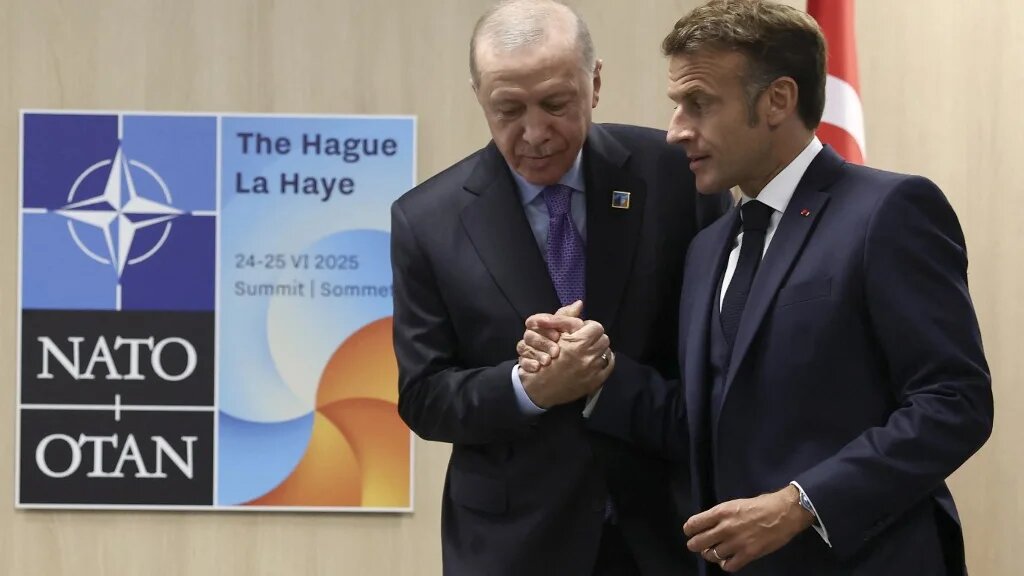France's President Emmanuel Macron (R) shakes hands with Turkey's President Recep Tayyip Erdogan during their meeting on the sideline of the North Atlantic Treaty Organization (NATO) summit in The Hague on June 25, 2025. (Christian Hartmann / POOL / AFP)