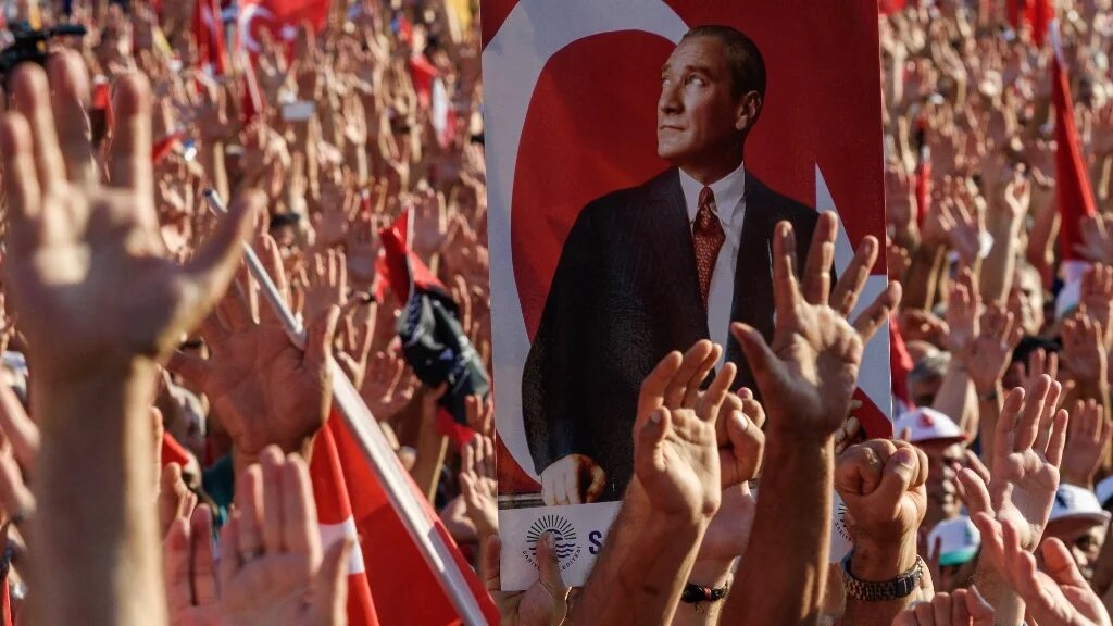 Demonstrators rise their hands and hold a potrait picture of Mustafa Kemal Ataturk, founder of modern Turkey, as they gather at Taksim Square in Istanbul on July 24, 2016 (AFP)