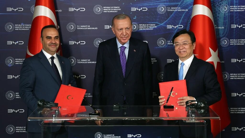 Turkish President Recep Tayyip Erdogan (C), Wang Chuanfu (L), chairman and CEO of Chinese conglomerate manufacturing company BYD and Turkish Minister of Industry and Technology Mehmet Fatih Kacir (R) taking part in a signing ceremony in Istanbul on 8 July 2024 (Handout)