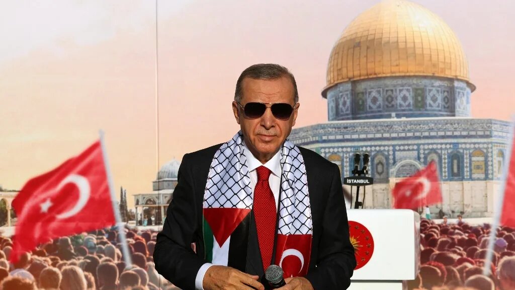 Turkish President Tayyip Erdogan, wearing a scarf with the Palestinian and Turkish flags, stands on the stage during a rally organised by the AKP party in solidarity with the Palestinians in Gaza, in Istanbul on October 28, 2023. (AFP)