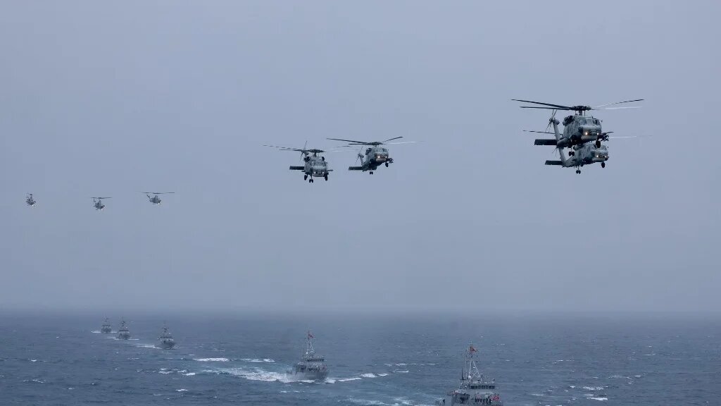 Turkish Navy SH-70 (S-70B SeaHawk) helicopters and Aydin class TCG Akcakoca (M-268) (R), TCG Anamur (M-269) (2nd R) and other ships participate in the live-fire phase of the "Blue Homeland-2026" (Mavi Vatan) tactical military exercises in the eastern Mediterranean Sea, in Antalya on April 9, 2026. (Adem Altan / AFP)