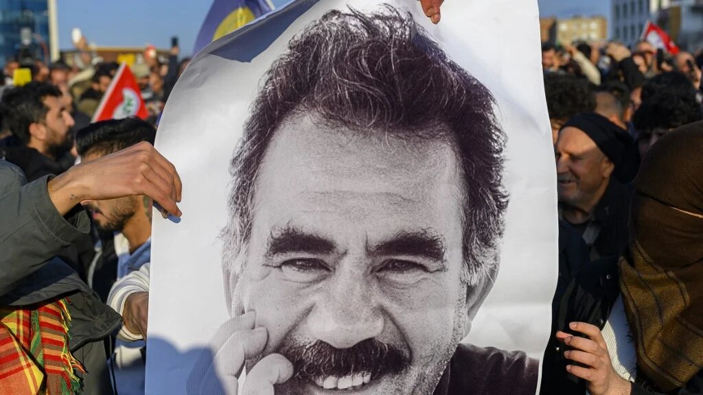Supporters display a poster of Abdullah Ocalan after he called on the PKK to disarm and dissolve itself in Diyarbakir, southeastern Turkey on 27 February (Yasin Akgul/AFP)