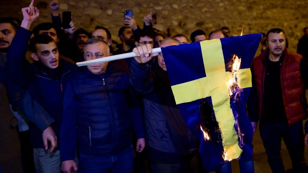 Protesters burn the national flag of Sweden as they demonstrate in front of the Consulate General of Sweden after Rasmus Paludan, leader of Danish far-right political party Hard Line and who also has Swedish citizenship burned a copy of the Koran near the Turkish Embassy in Stockholm, in Istanbul, on January 21, 2023. (AFP)