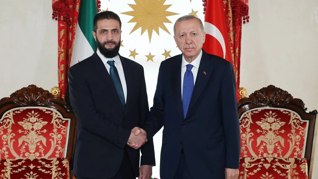 This handout photograph taken and released by the Turkish Presidential Press Service in Istanbul, Turkey on May 24, 2025, shows Turkish President Recep Tayyip Erdogan (R) and Syria's interim President Ahmed al-Sharaa (L) shaking hands during their meeting. (Handout / Turkish Presidency)