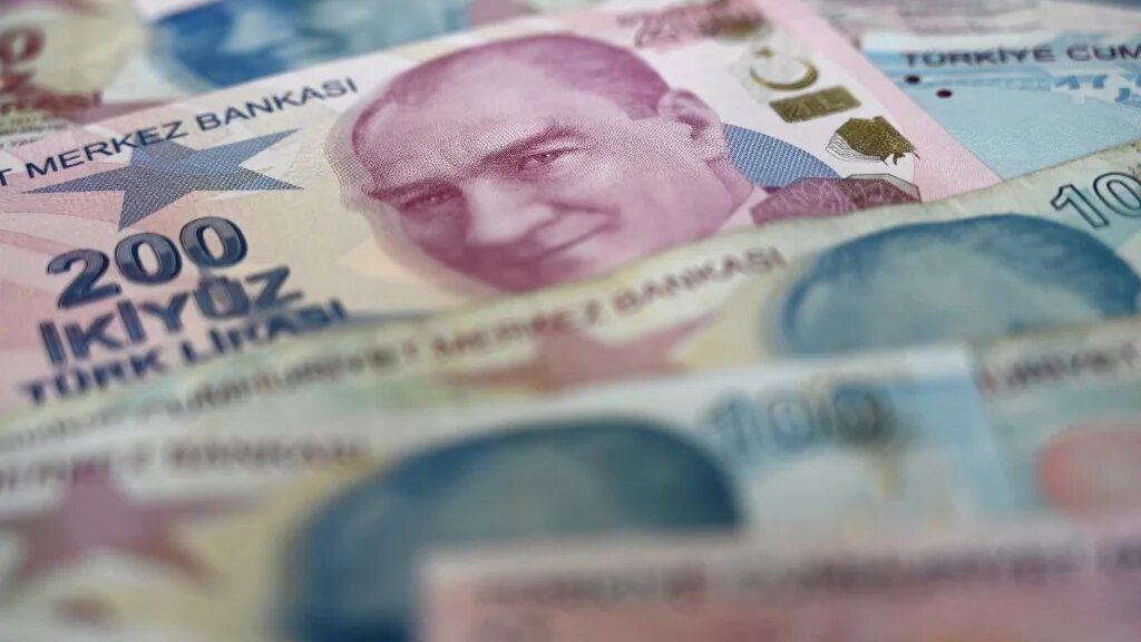 A picture taken in Istanbul shows US dollars banknotes and Turkish lira banknotes. (Ozan Kose / AFP)