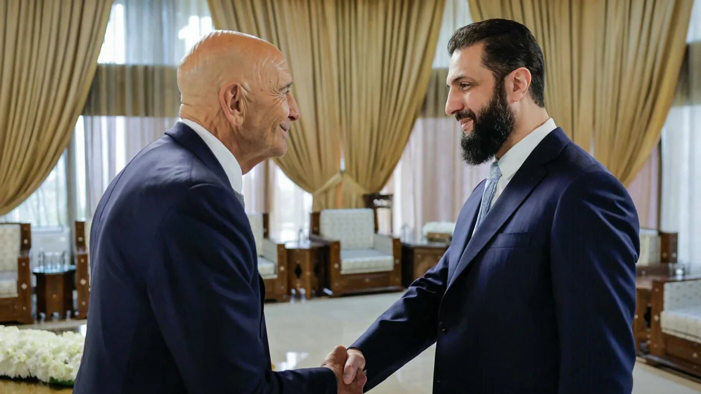  US envoy Tom Barrack shakes hands with Syrian President Ahmed al-Sharaa at the Presidential Palace in Damascus, 18 January 2026 (Syrian Presidency/AFP)
